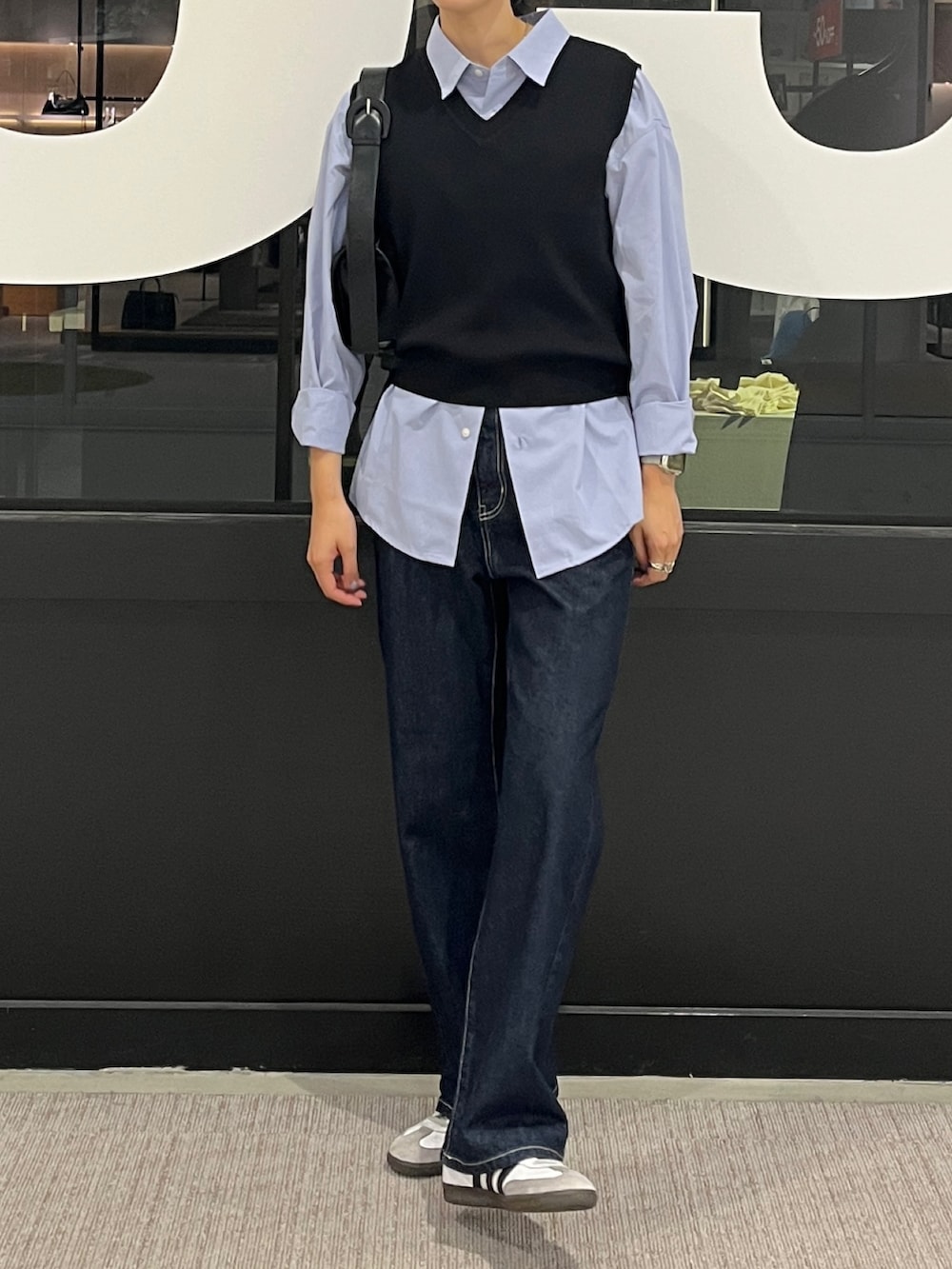 ブルー系のデニムパンツ、ブルー系のシャツ/ブラウス、ブラック系のベストを着用したレディースの秋コーディネートの2枚目の写真