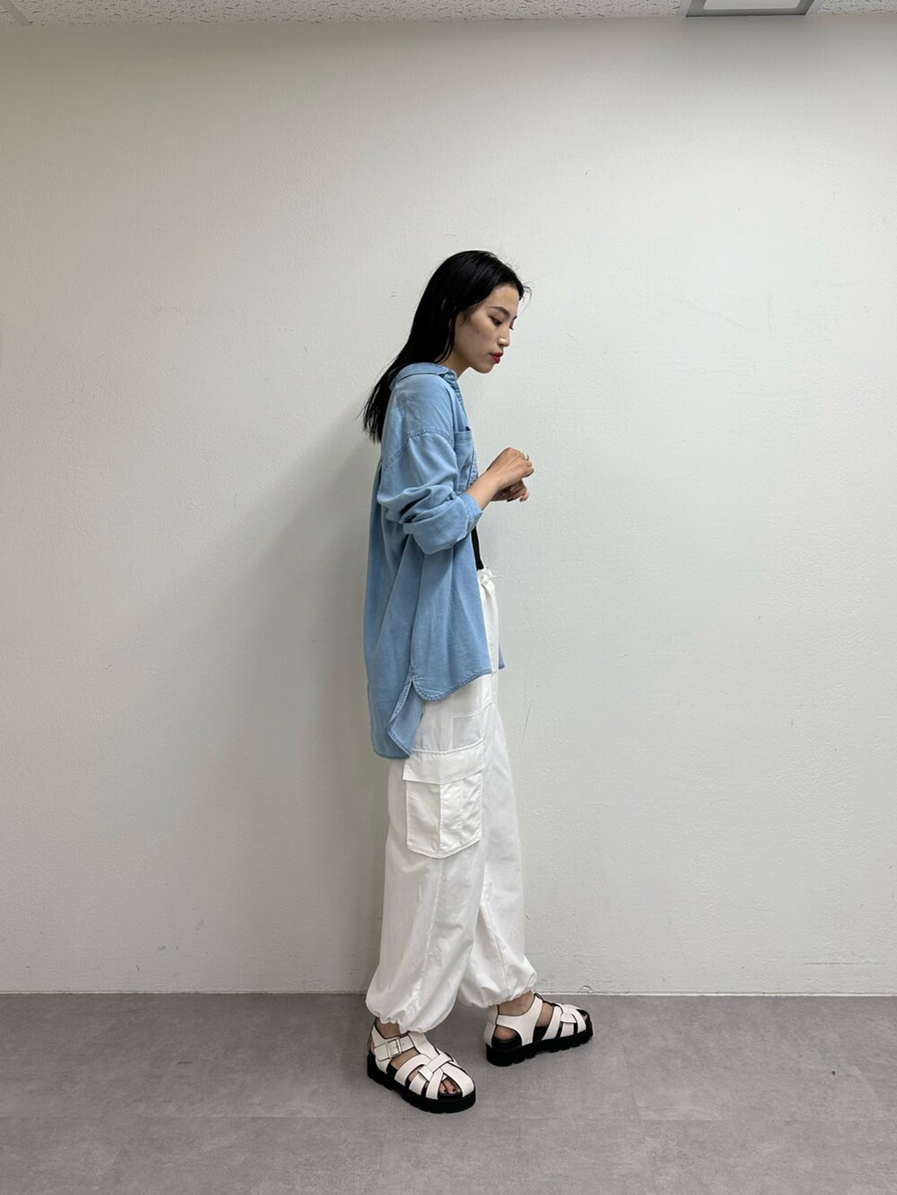 ホワイト系のカーゴパンツ、ホワイト系のサンダル、ブラック系のキャミソールを着用したレディースの春コーディネートの2枚目の写真