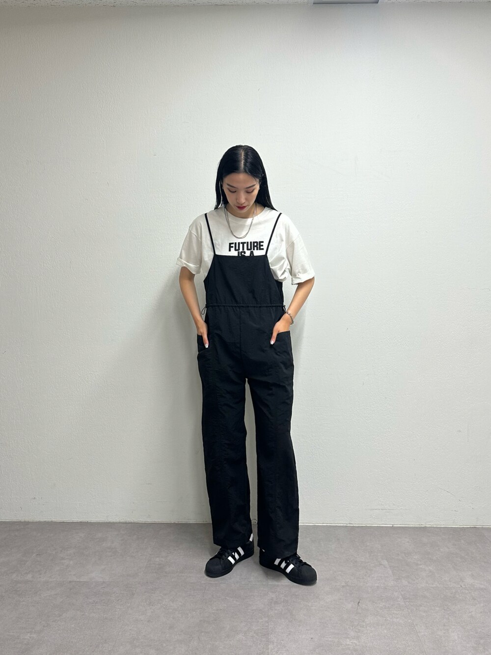 ブラック系のサロペット/オーバーオール、ホワイト系のTシャツ/カットソー、シルバー系のネックレスを着用したレディースの春コーディネートの2枚目の写真