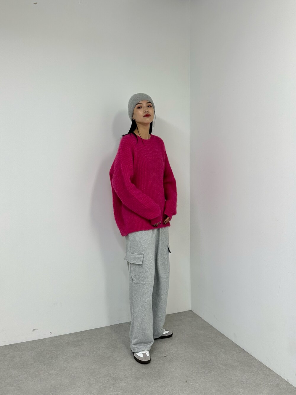 グレー系のカーゴパンツ、ピンク系のニット/セーター、グレー系のニットキャップ/ビーニーを着用したレディースの秋コーディネートの2枚目の写真