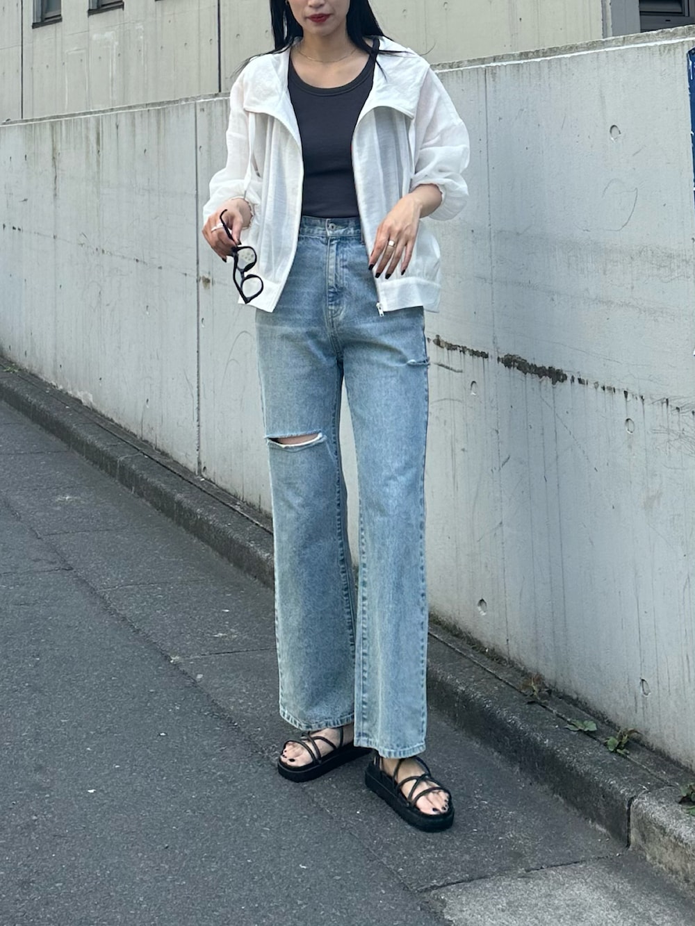 ブラック系のサンダル、ブルー系のデニムパンツ、ホワイト系のシャツ/ブラウスを着用したレディースの春コーディネートの2枚目の写真