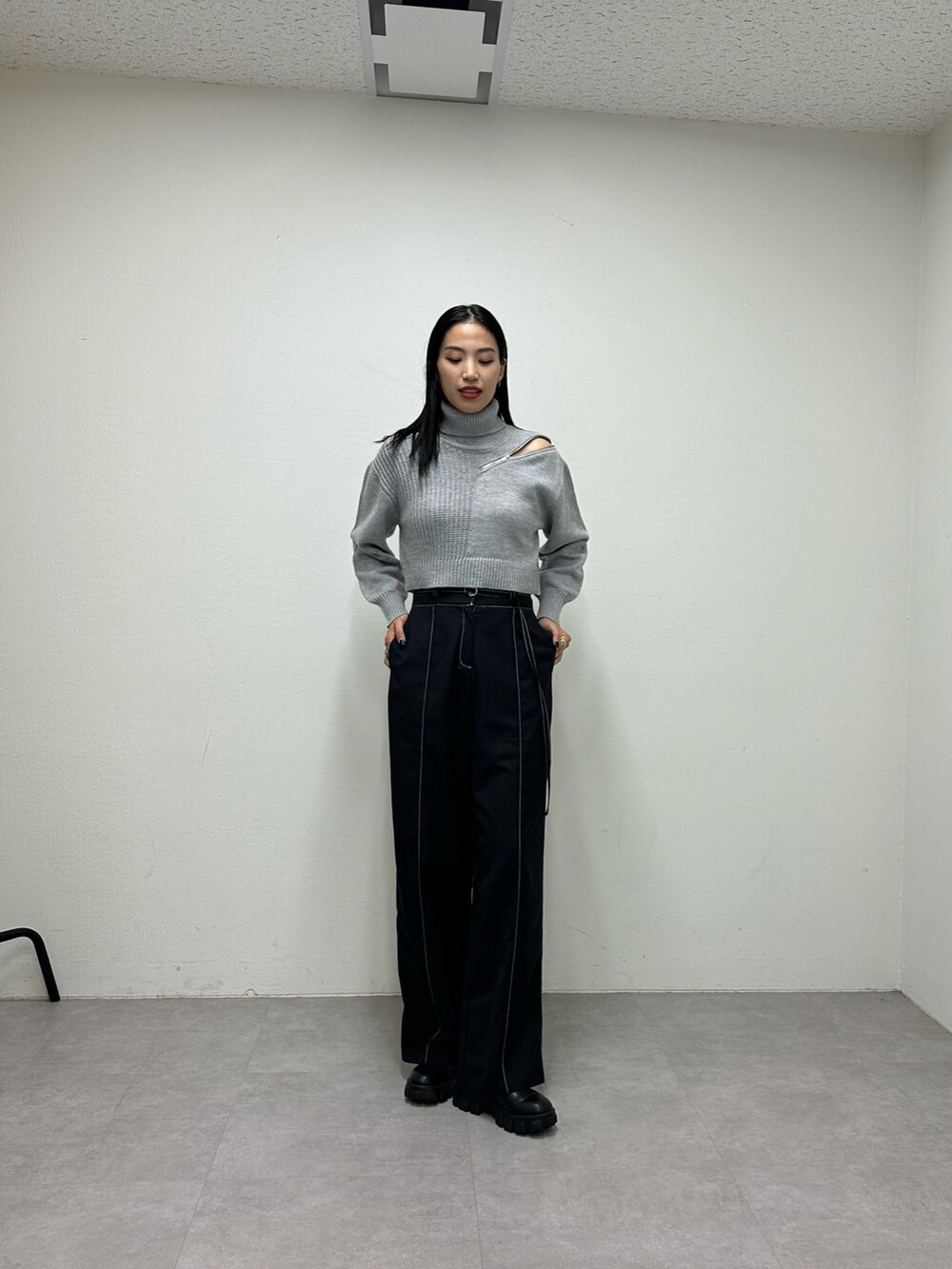 ブラック系のその他パンツ、グレー系のニット/セーター、ブラック系のブーツを着用したレディースの秋コーディネートの2枚目の写真