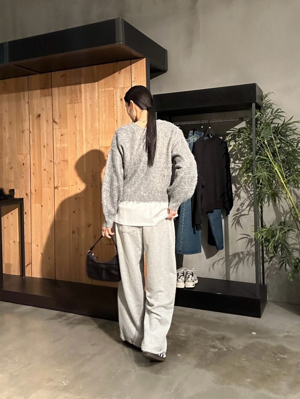 グレー系のスウェットパンツ、グレー系のニット/セーター、ブラック系のハンドバッグを着用したレディースの秋コーディネートの3枚目の写真