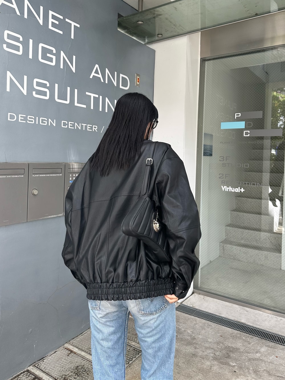 ブラック系のブルゾン、ブラック系のショルダーバッグを着用したレディースの夏コーディネートの3枚目の写真