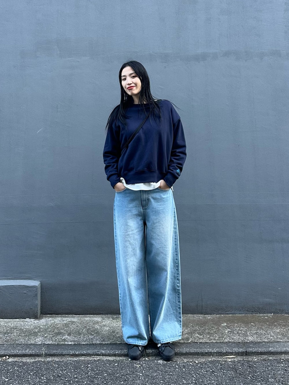 ブルー系のデニムパンツ、ブルー系のスウェット、ブラック系のバックパック/リュックを着用したレディースの冬コーディネートの4枚目の写真