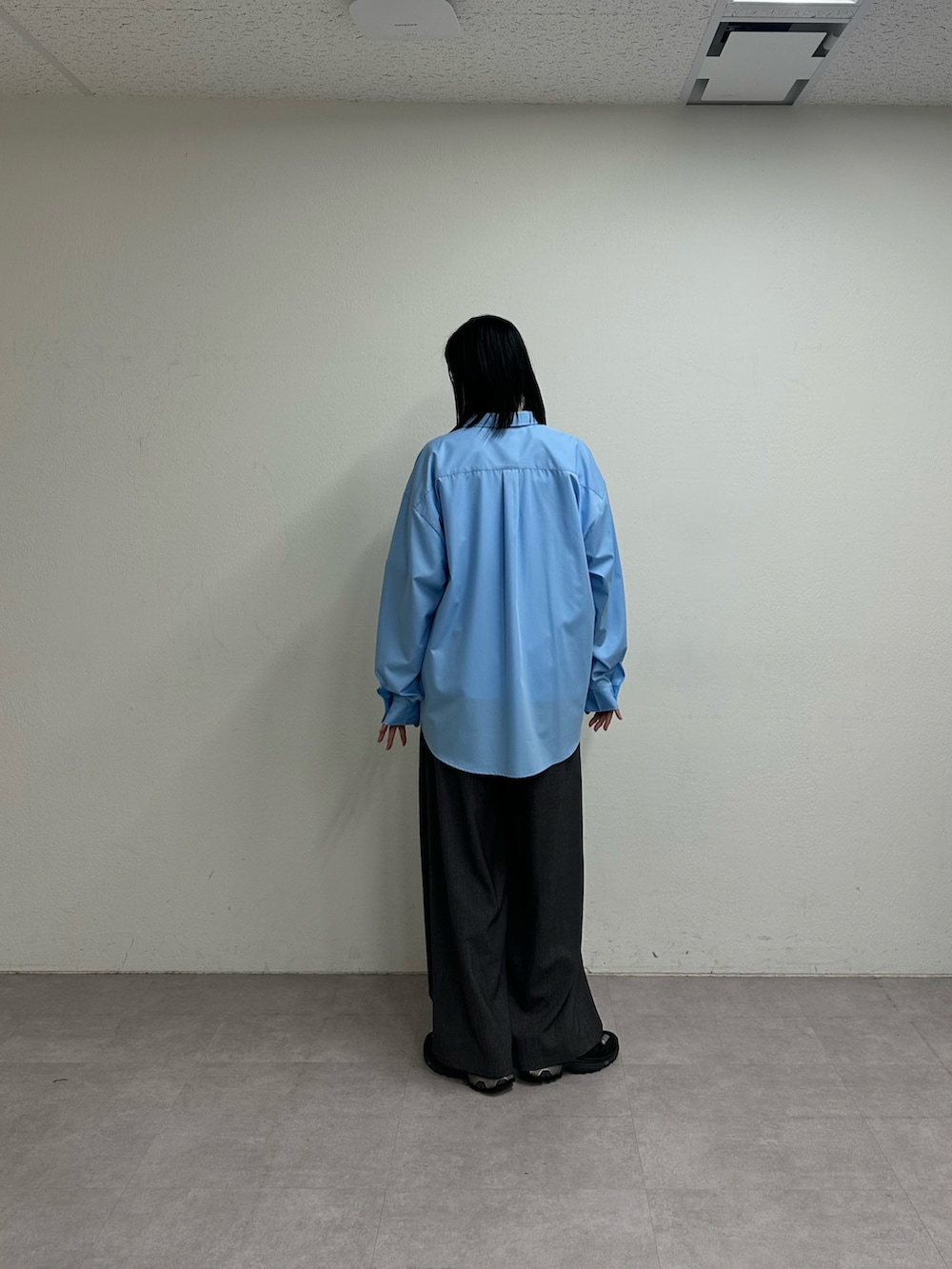 ホワイト系のTシャツ/カットソー、ブルー系のシャツ/ブラウス、グレー系のスラックスを着用したレディースの春コーディネートの3枚目の写真