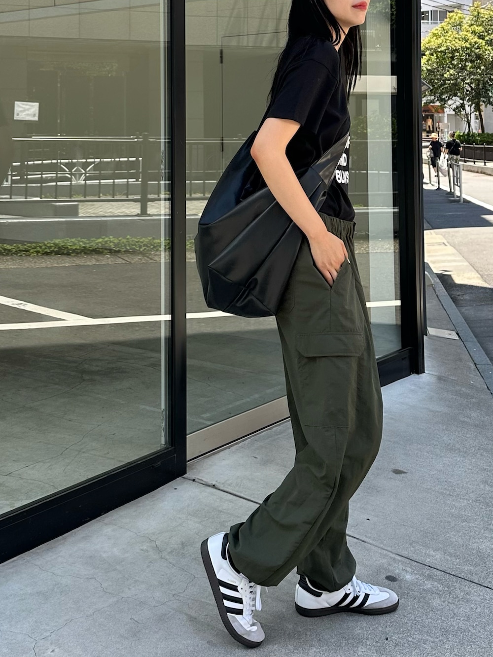 グリーン系のカーゴパンツ、ブラック系のTシャツ/カットソー、ブラック系のショルダーバッグを着用したレディースの夏コーディネートの2枚目の写真