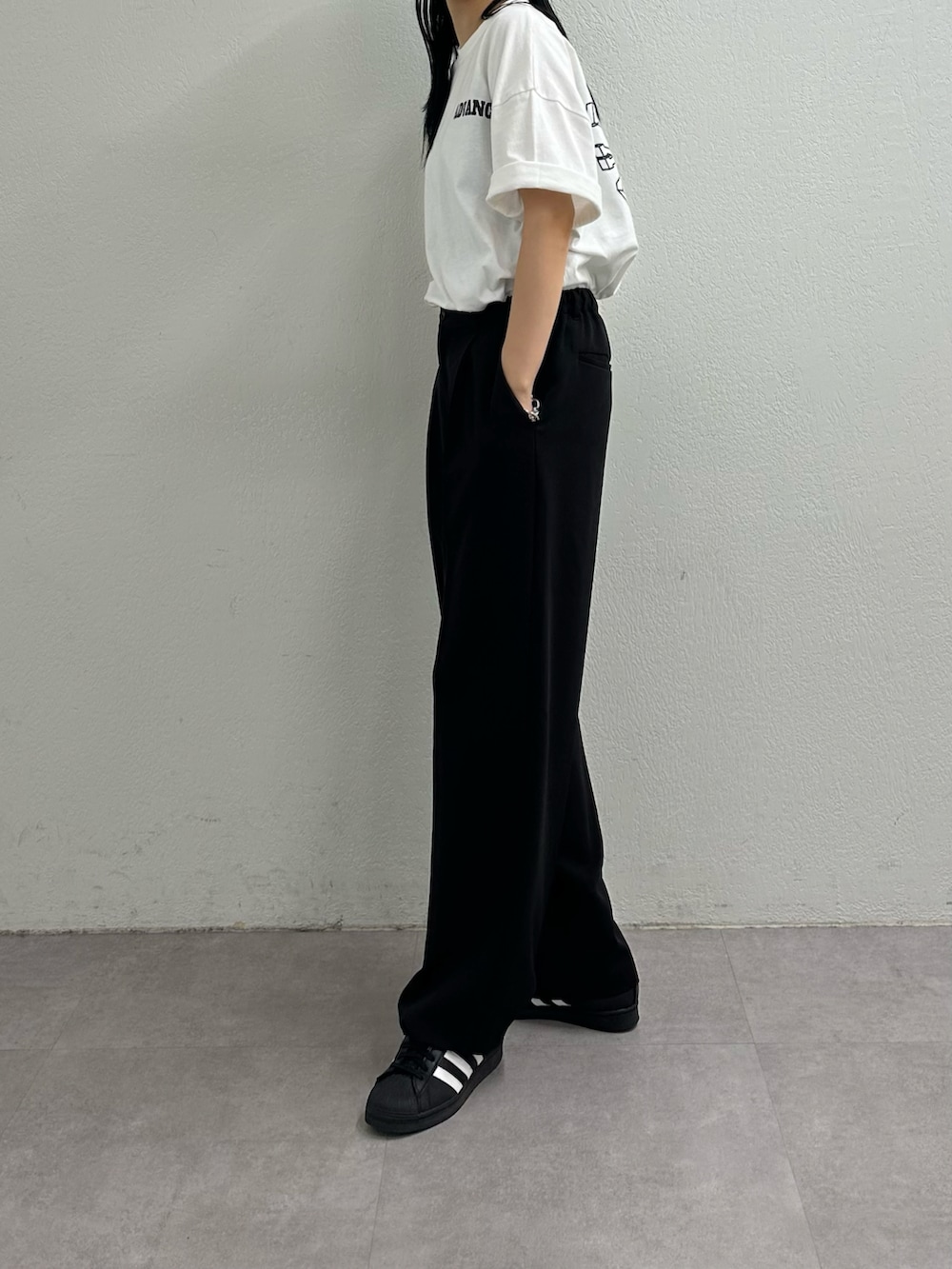 ブラック系のスラックス、ホワイト系のTシャツ/カットソーを着用したレディースの夏コーディネートの4枚目の写真