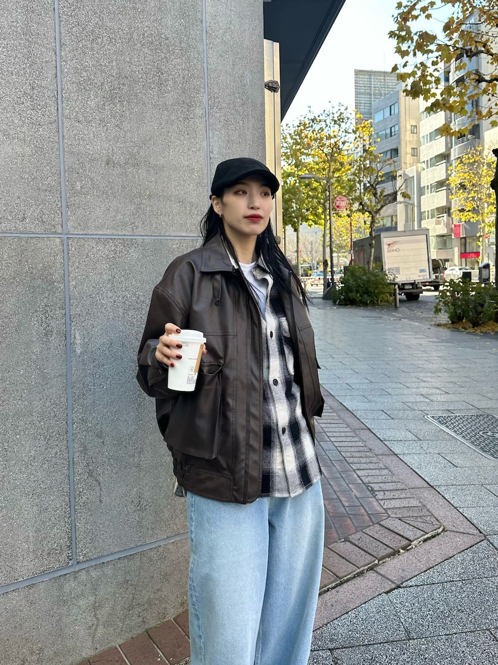 ブルー系のデニムパンツ、ブラック系のトップス、ブラック系のハンドバッグを着用したレディースの冬コーディネートの4枚目の写真