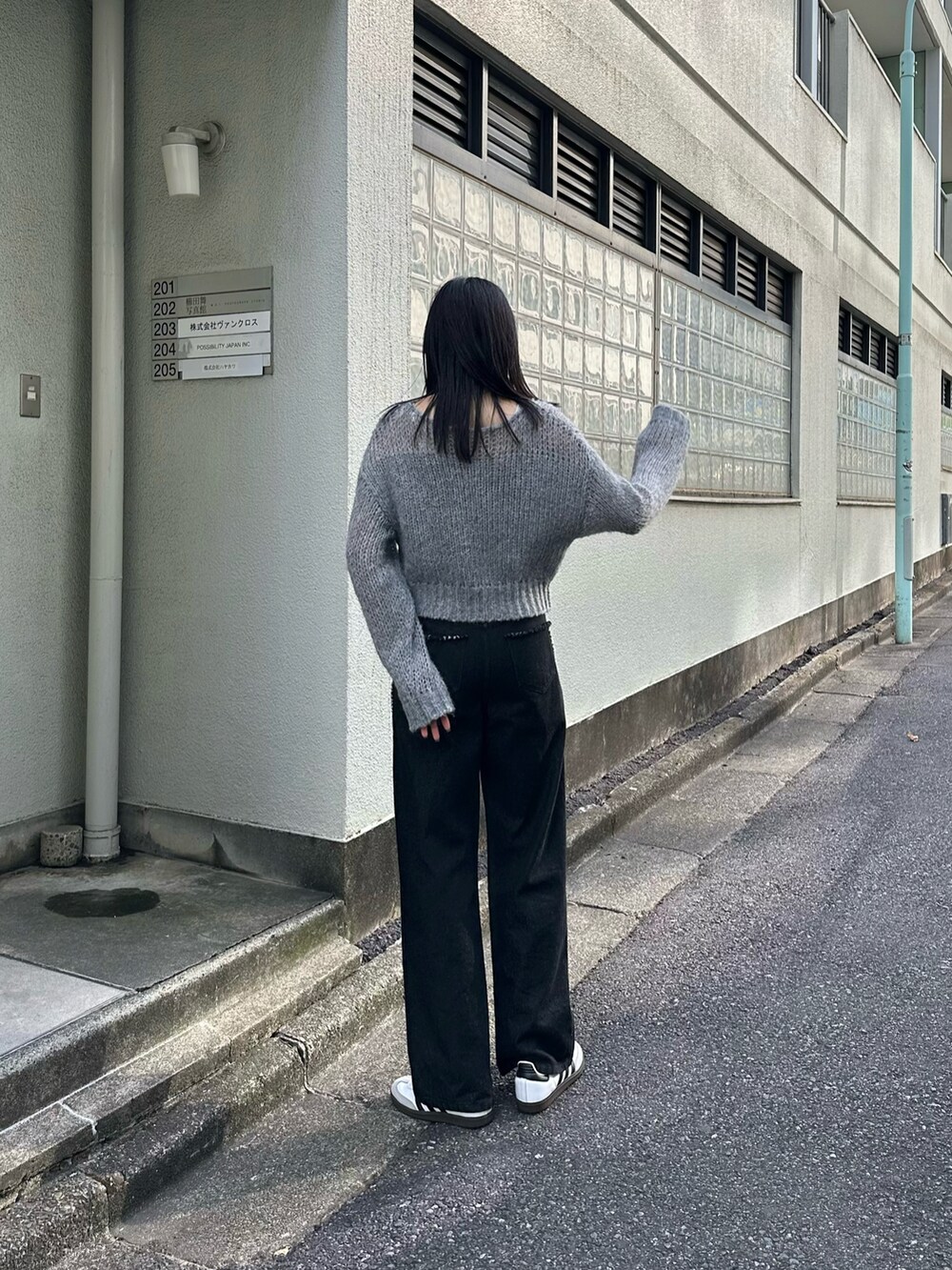 ブラック系のデニムパンツ、グレー系のニット/セーターを着用したレディースの夏コーディネートの2枚目の写真