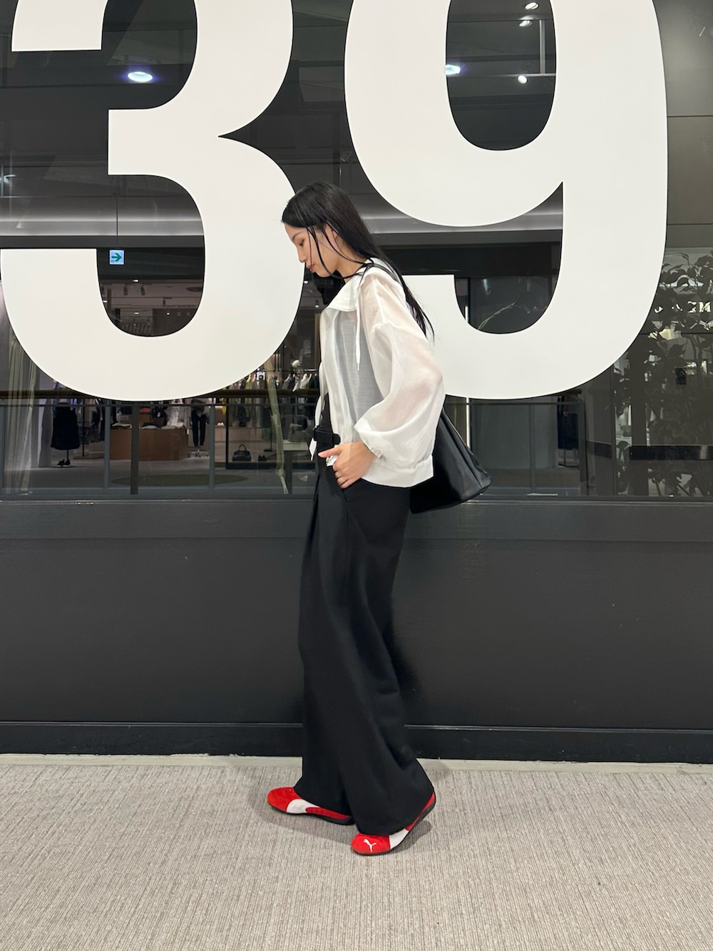 ホワイト系のマウンテンパーカー、ブラック系のタンクトップ、ブラック系のスラックスを着用したレディースの春コーディネートの2枚目の写真