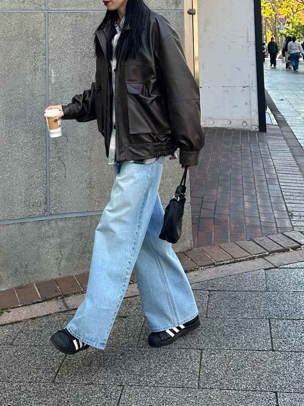 ブルー系のデニムパンツ、ブラック系のトップス、ブラック系のハンドバッグを着用したレディースの冬コーディネートの2枚目の写真