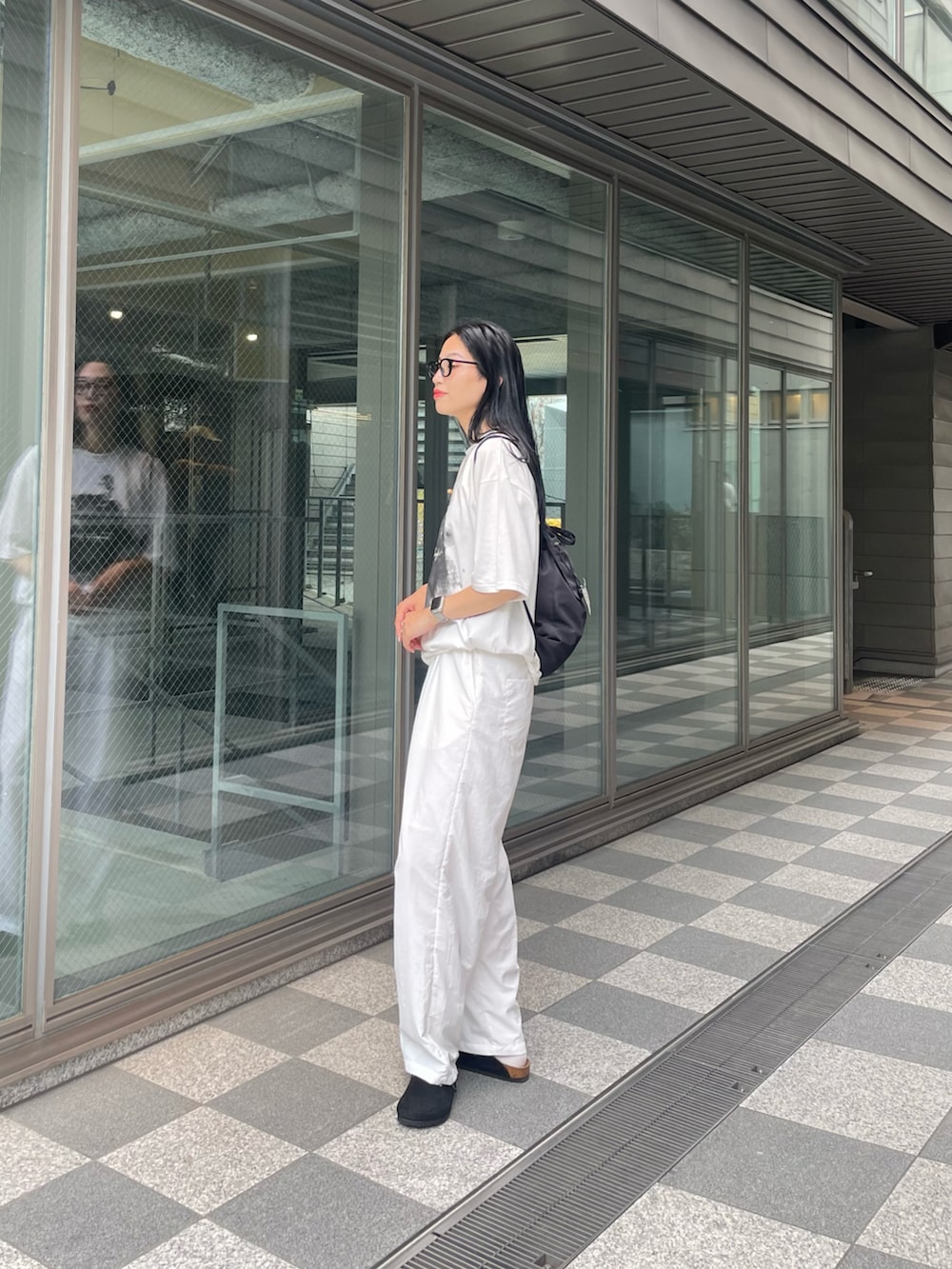 ホワイト系のTシャツ/カットソー、ブラック系のバックパック/リュック、ホワイト系のその他パンツを着用したレディースの夏コーディネートの3枚目の写真