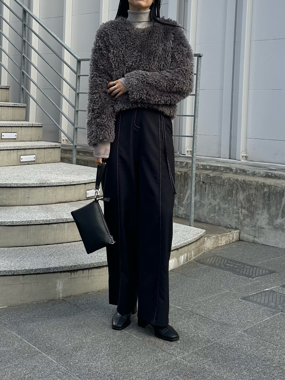 ブラック系のショルダーバッグ、ブラック系のその他パンツ、グレー系のTシャツ/カットソーを着用したレディースの冬コーディネートの4枚目の写真