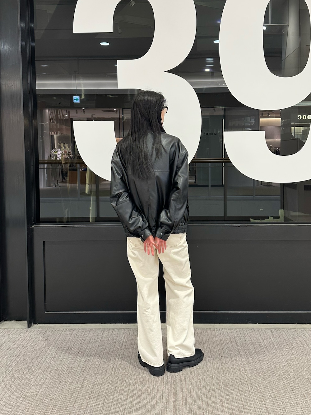 ホワイト系のデニムパンツ、ブラック系のブルゾンを着用したレディースの冬コーディネートの3枚目の写真