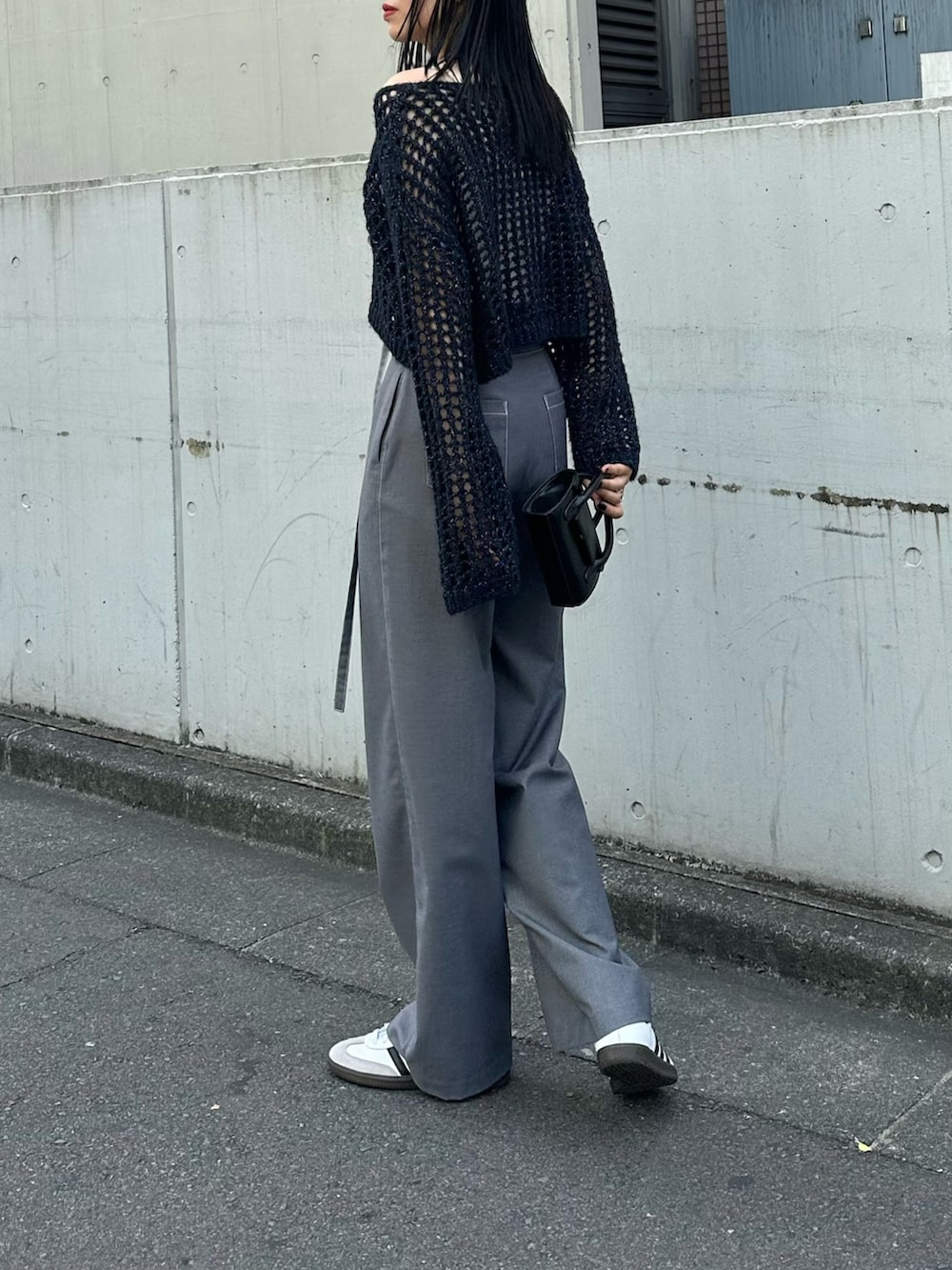 ブルー系のニット/セーター、ブラック系のショルダーバッグを着用したレディースの夏コーディネートの2枚目の写真