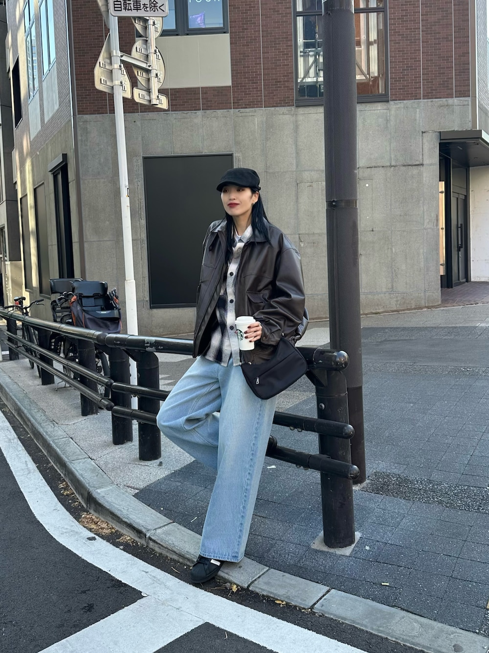 ブルー系のデニムパンツ、ブラック系のトップス、ブラック系のハンドバッグを着用したレディースの冬コーディネートの3枚目の写真