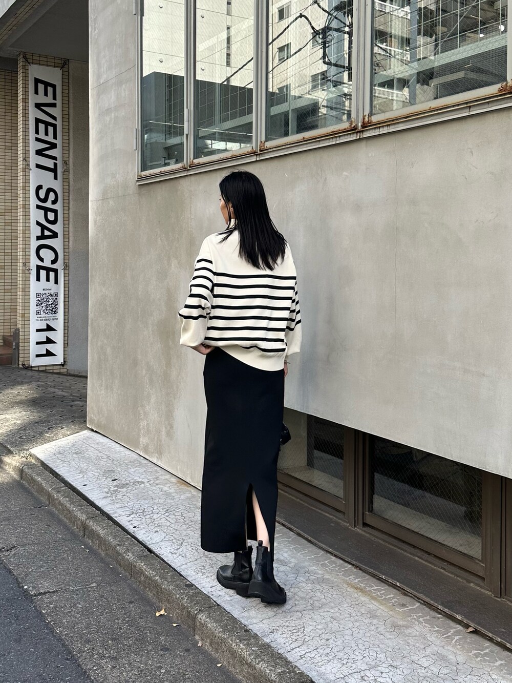 ホワイト系のニット/セーター、ブラック系のスカート、ブラック系のショルダーバッグを着用したレディースの夏コーディネートの2枚目の写真