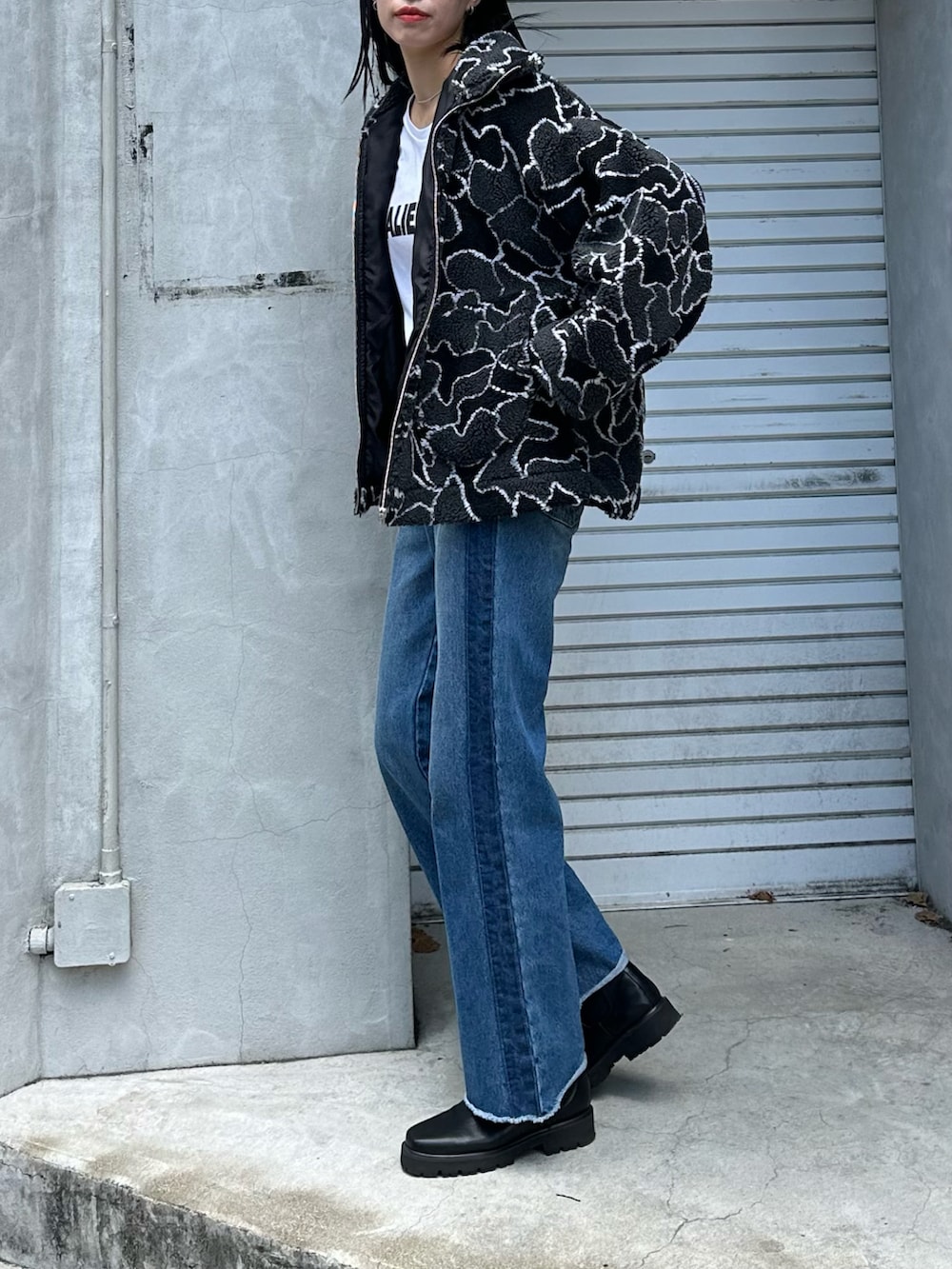 ブルー系のデニムパンツ、ホワイト系のTシャツ/カットソー、ブラック系のブルゾンを着用したレディースの夏コーディネートの2枚目の写真