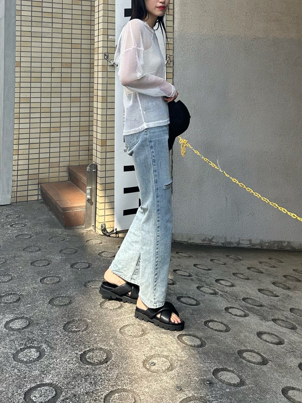 ホワイト系のパーカー、ホワイト系のキャミソール、ブルー系のデニムパンツを着用したレディースの春コーディネートの2枚目の写真