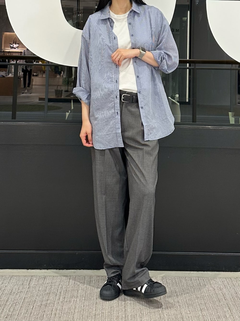 ブルー系のシャツ/ブラウス、ホワイト系のTシャツ/カットソー、グレー系のスラックスを着用したレディースの春コーディネートの4枚目の写真