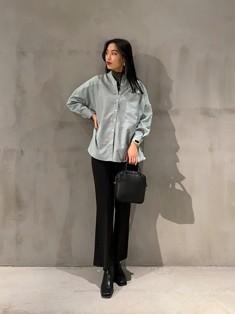 ブラック系のボストンバッグ、ブラック系のブーツ、ブラック系のその他パンツを着用したレディースの冬コーディネートの2枚目の写真