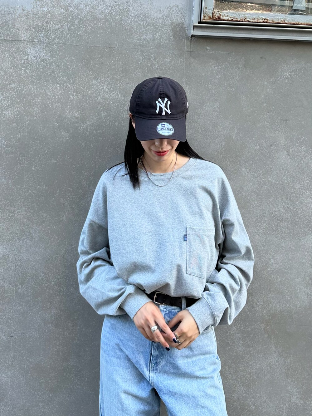 ブルー系のデニムパンツ、ブラック系のブーツ、グレー系のTシャツ/カットソーを着用したレディースの秋コーディネートの3枚目の写真