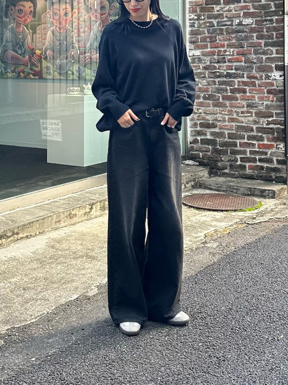 ブラック系のデニムパンツ、ブラック系のニット/セーターを着用したレディースの秋コーディネートの3枚目の写真