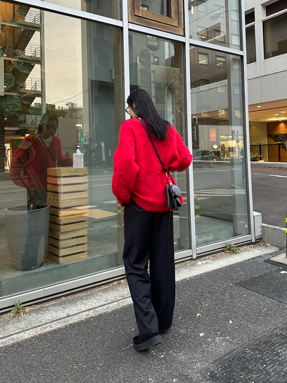 レッド系のカーディガン/ボレロ、ブラック系のその他パンツ、ブラック系のモカシン/デッキシューズを着用したレディースの冬コーディネートの3枚目の写真