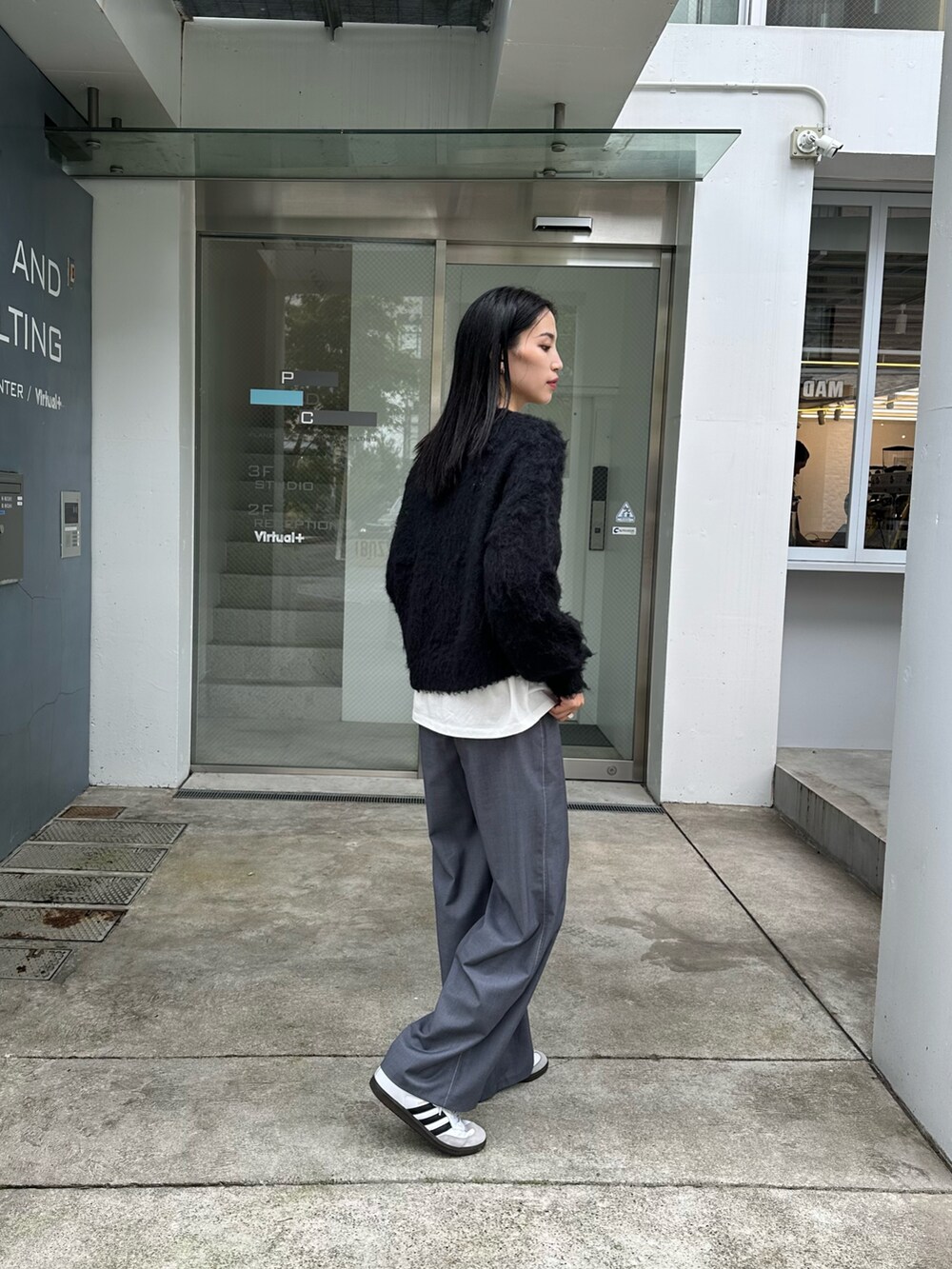 ブラック系のニット/セーター、グレー系のその他パンツ、ブラック系のショルダーバッグを着用したレディースの秋コーディネートの2枚目の写真