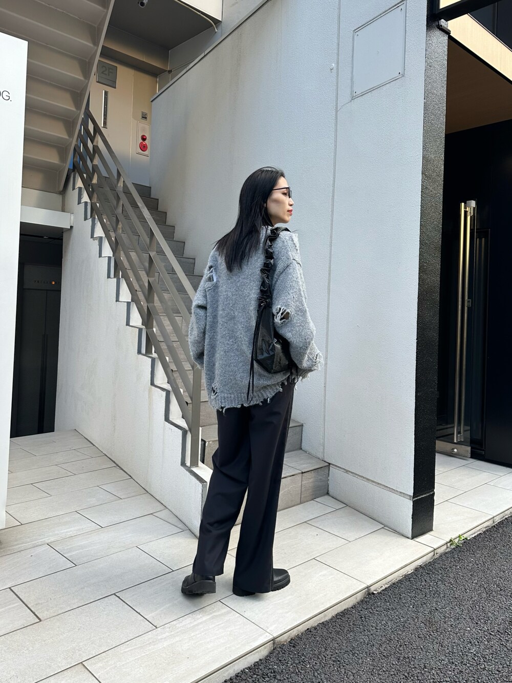 グレー系のニット/セーター、ブラック系のショルダーバッグ、ブラック系のその他パンツを着用したレディースの秋コーディネートの3枚目の写真