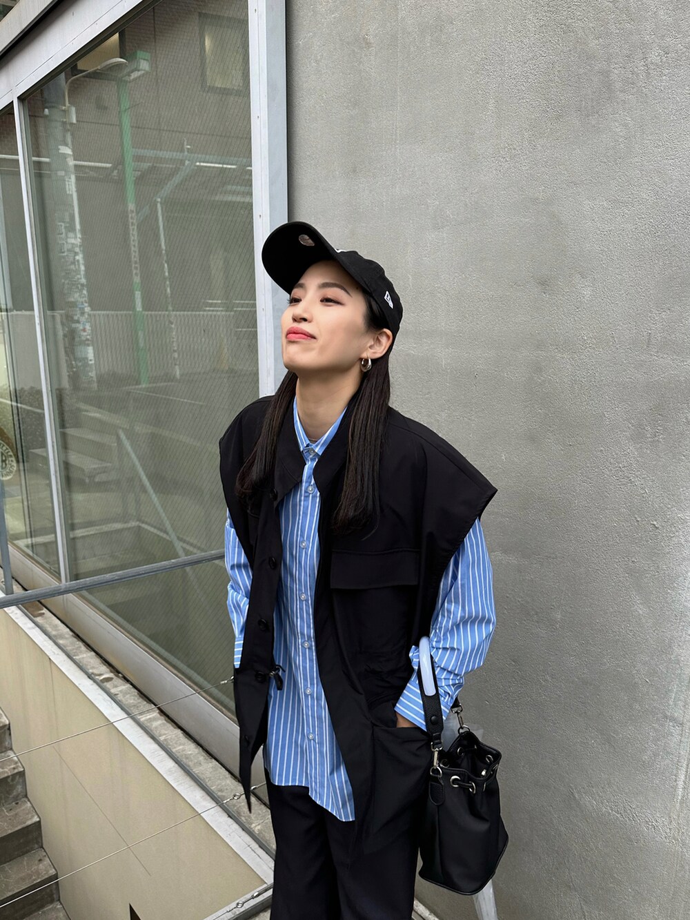 ブラック系のパンツ、ブラック系のスニーカー、ブルー系のシャツ/ブラウスを着用したレディースの春コーディネートの4枚目の写真