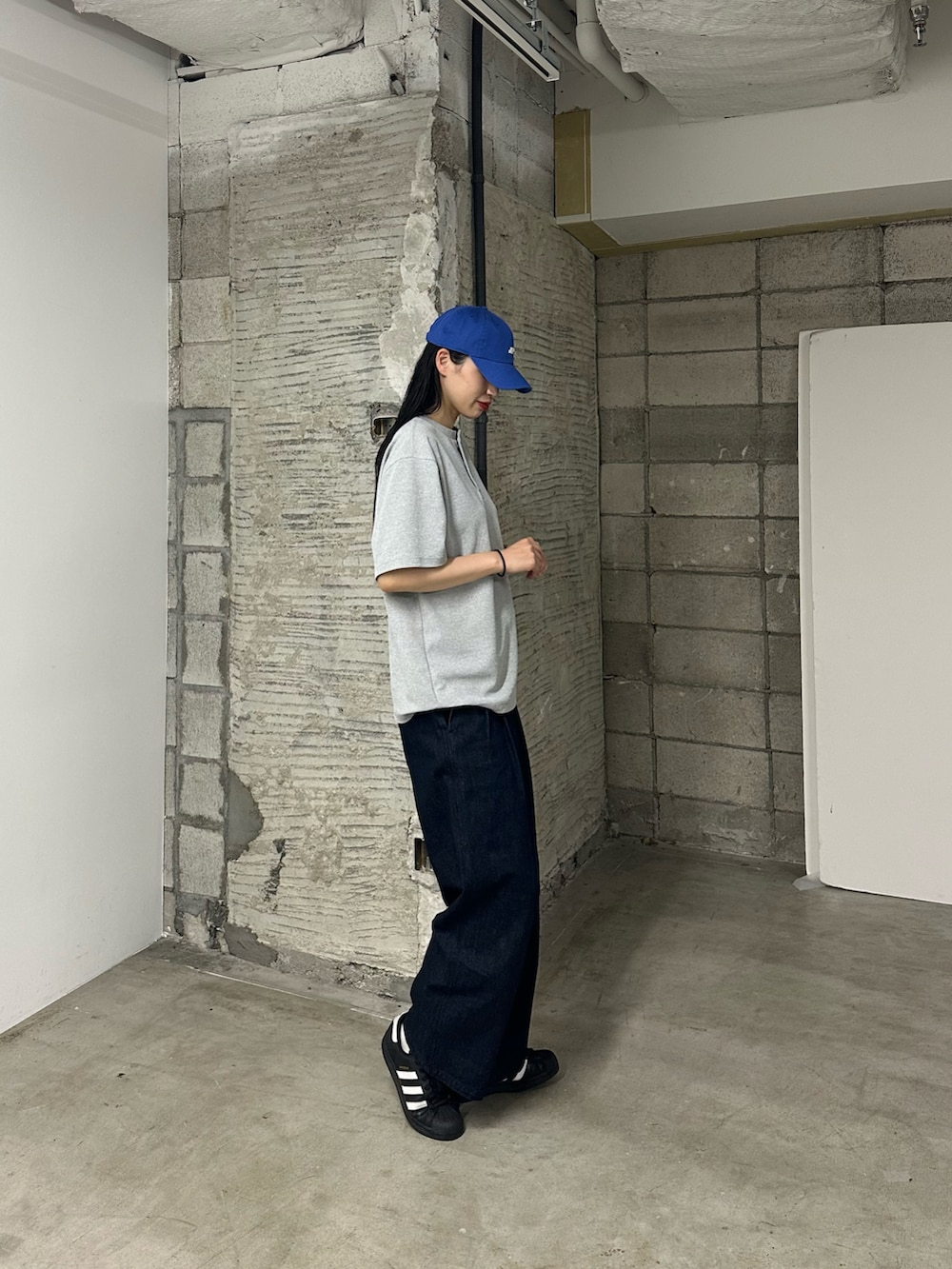 ブルー系のデニムパンツ、グレー系のTシャツ/カットソーを着用したレディースの春コーディネートの2枚目の写真