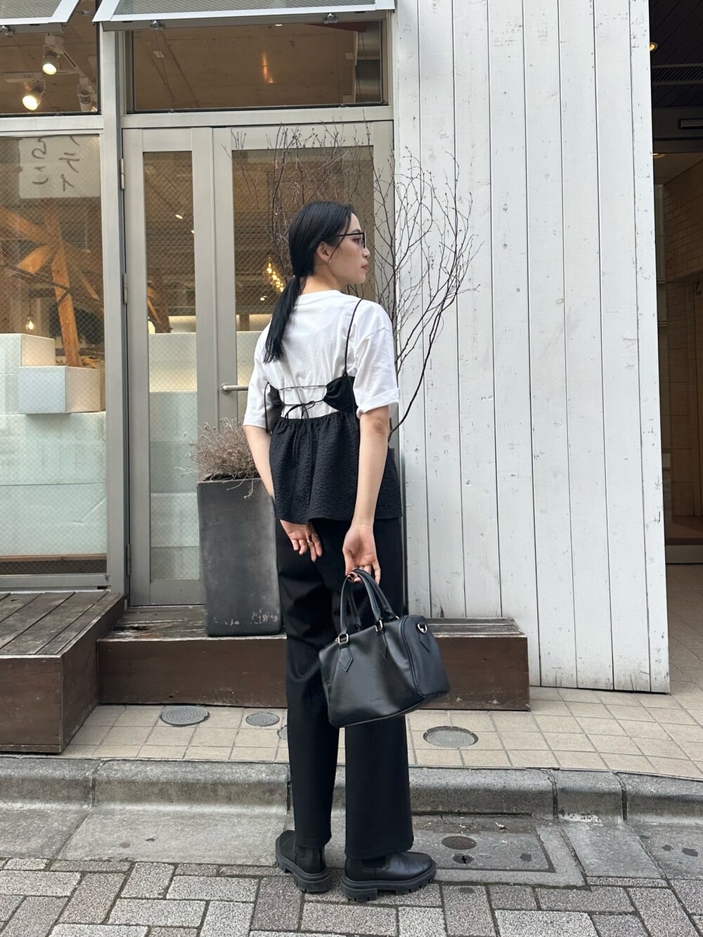 ブラック系のその他パンツ、ブラック系のキャミソール、ホワイト系のTシャツ/カットソーを着用したレディースの春コーディネートの2枚目の写真