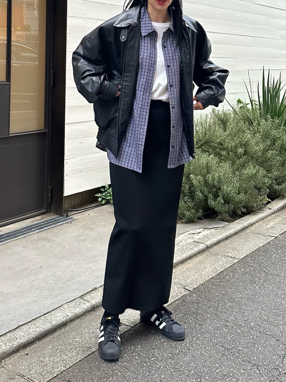 ブラック系のブルゾン、ブルー系のシャツ/ブラウス、ブラック系のスカートを着用したレディースの冬コーディネートの2枚目の写真