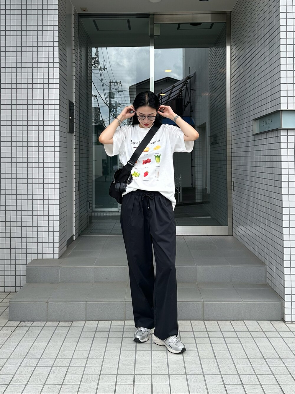 ブラック系のその他パンツ、ブラック系のメッセンジャーバッグを着用したレディースの夏コーディネートの2枚目の写真