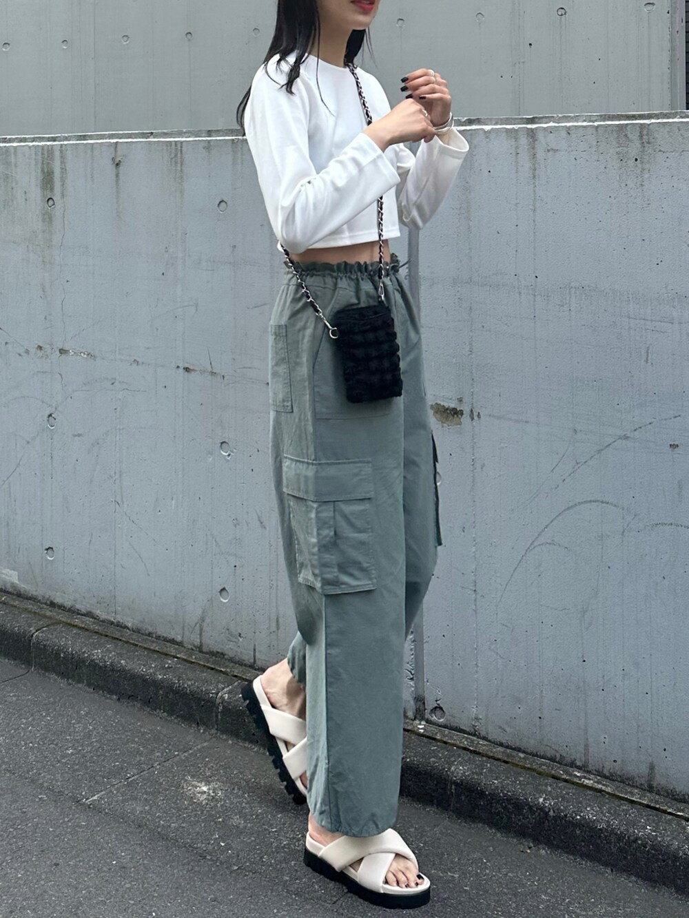 グリーン系のカーゴパンツ、ホワイト系のサンダル、ホワイト系のカーディガン/ボレロを着用したレディースの春コーディネートの3枚目の写真