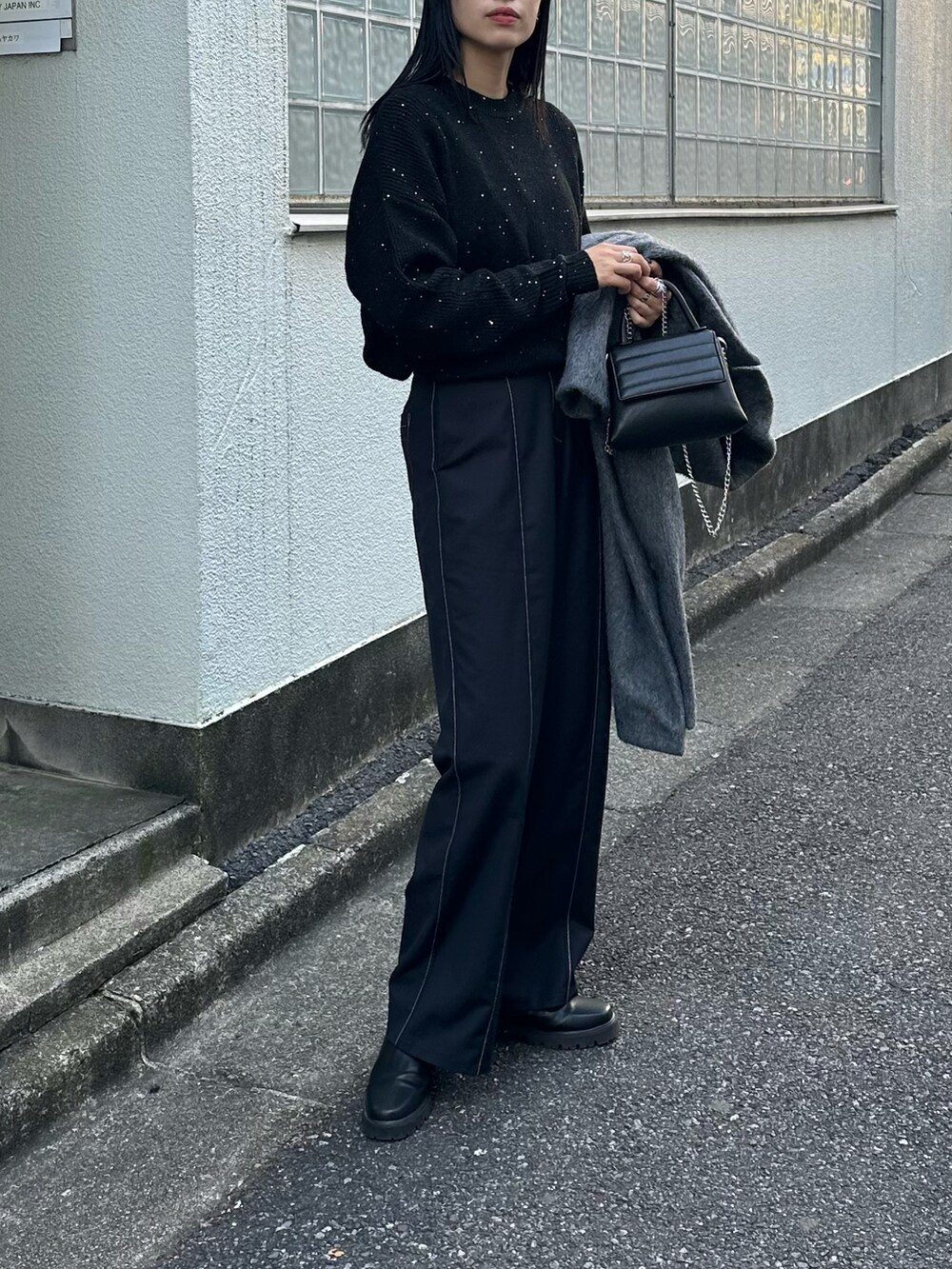 ブラック系のショルダーバッグ、グレー系のチェスターコート、ブラック系のニット/セーターを着用したレディースの秋コーディネートの4枚目の写真