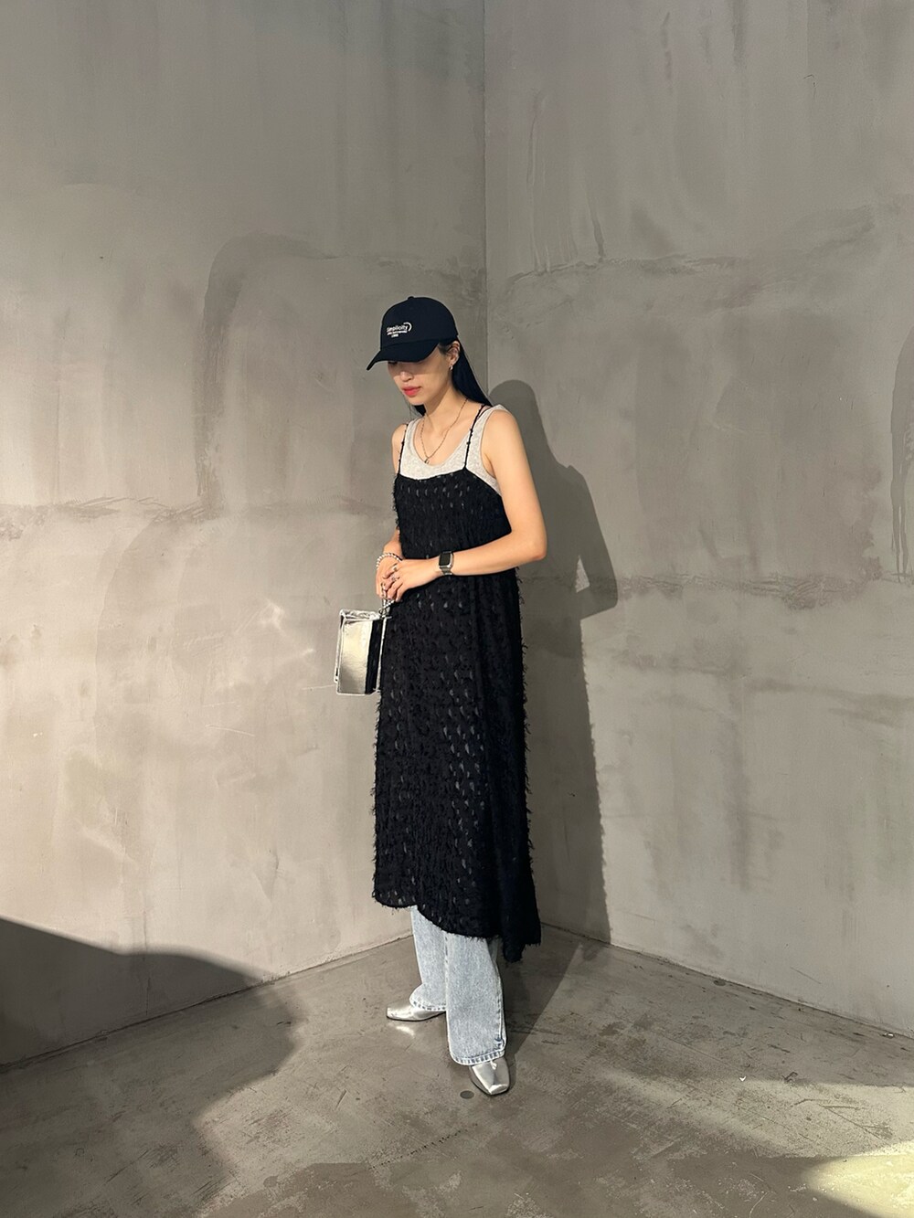 ブラック系のワンピース、グレー系のタンクトップ、ブルー系のデニムパンツを着用したレディースの夏コーディネートの2枚目の写真