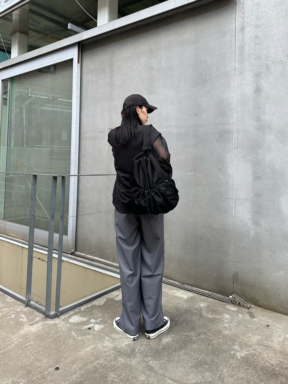 ブラック系のショルダーバッグ、グレー系のその他パンツ、ブラック系のTシャツ/カットソーを着用したレディースの秋コーディネートの3枚目の写真