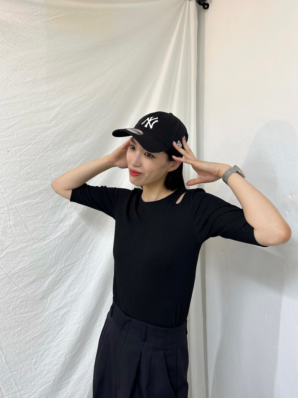 ブラック系のTシャツ/カットソー、ブラック系のスニーカー、ブラック系のパンツを着用したレディースの春コーディネートの2枚目の写真