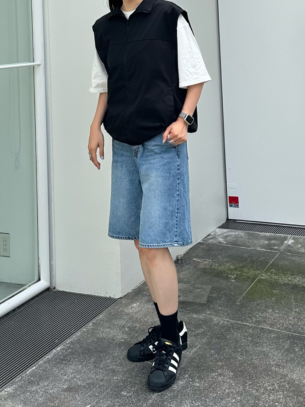 ブラック系のベスト、ホワイト系のTシャツ/カットソーを着用したレディースの夏コーディネートの3枚目の写真