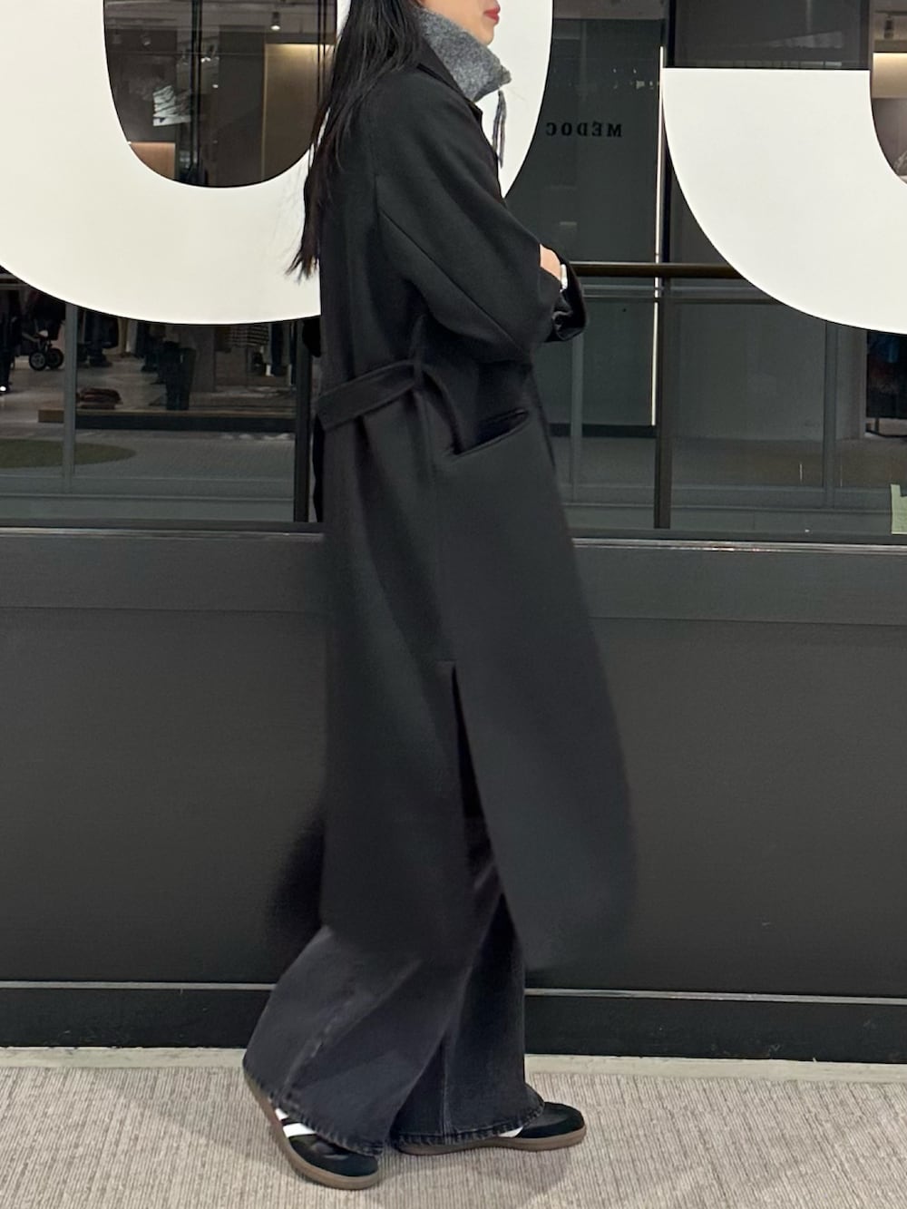 ブラック系のその他アウター、ホワイト系のTシャツ/カットソー、グレー系のニット/セーターを着用したレディースの冬コーディネートの2枚目の写真