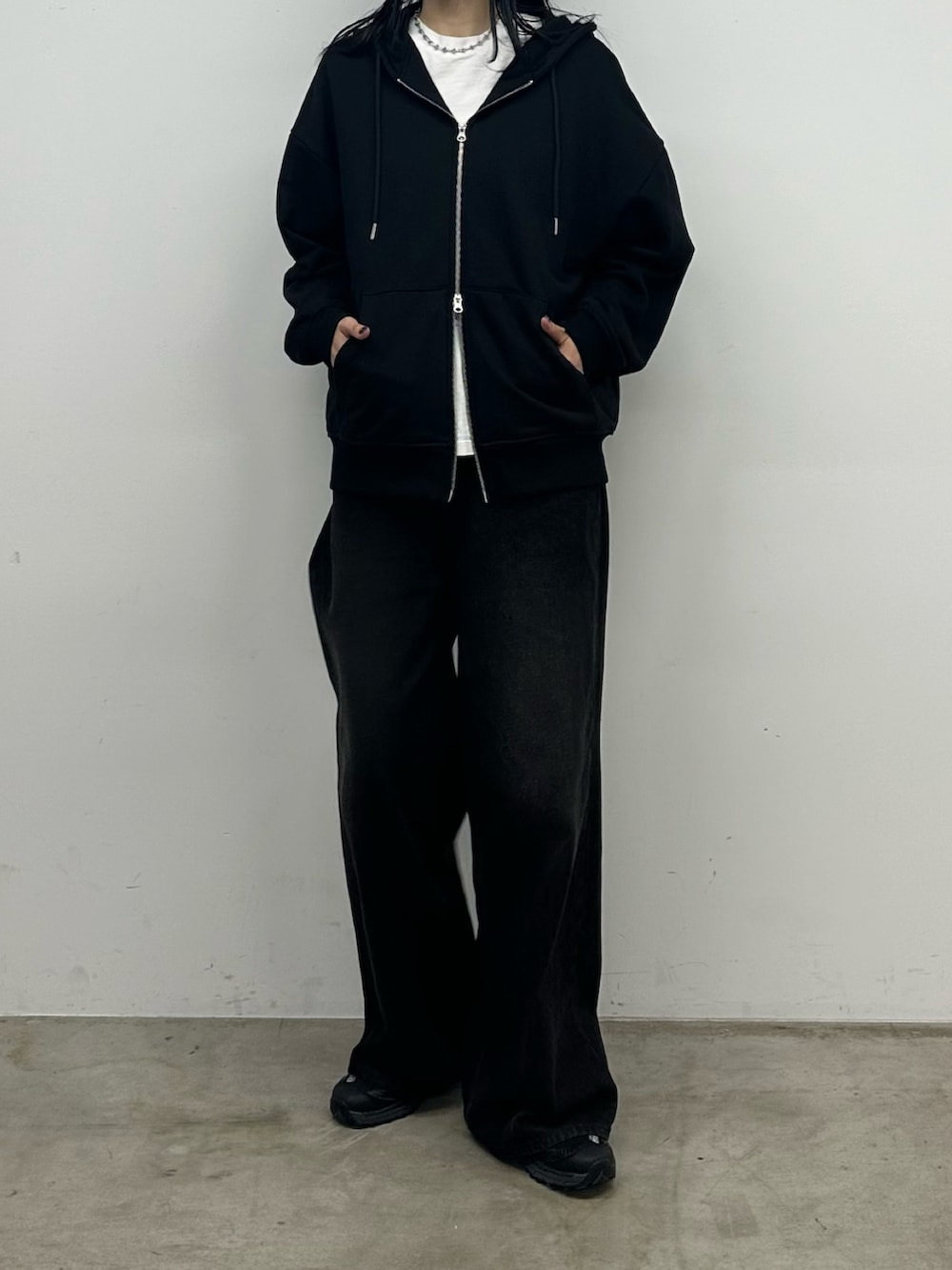 ブラック系のデニムパンツ、ブラック系のパーカーを着用したレディースの秋コーディネートの4枚目の写真