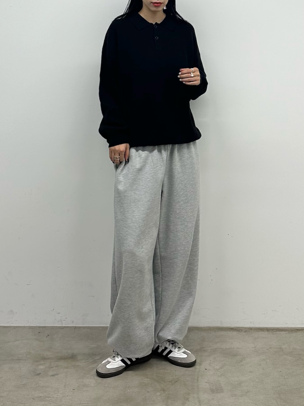 ブラック系のニット/セーター、グレー系のスウェットパンツを着用したレディースの秋コーディネートの2枚目の写真