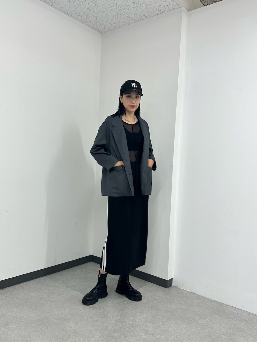 グレー系のテーラードジャケット、ブラック系のTシャツ/カットソー、ブラック系のスカートを着用したレディースの夏コーディネートの2枚目の写真