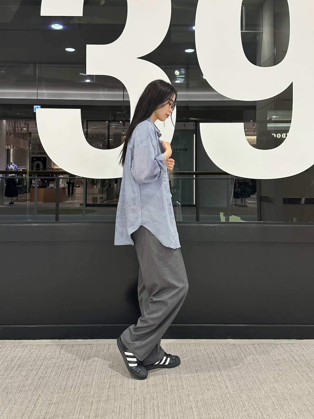 ブルー系のシャツ/ブラウス、ホワイト系のTシャツ/カットソー、グレー系のスラックスを着用したレディースの春コーディネートの2枚目の写真