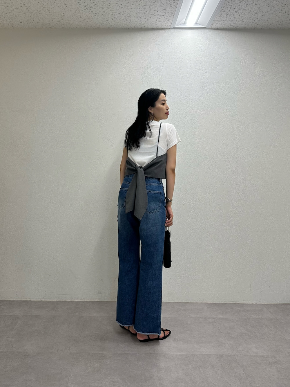 ブルー系のデニムパンツ、グレー系のトップス、ブラック系のサンダルを着用したレディースの夏コーディネートの2枚目の写真