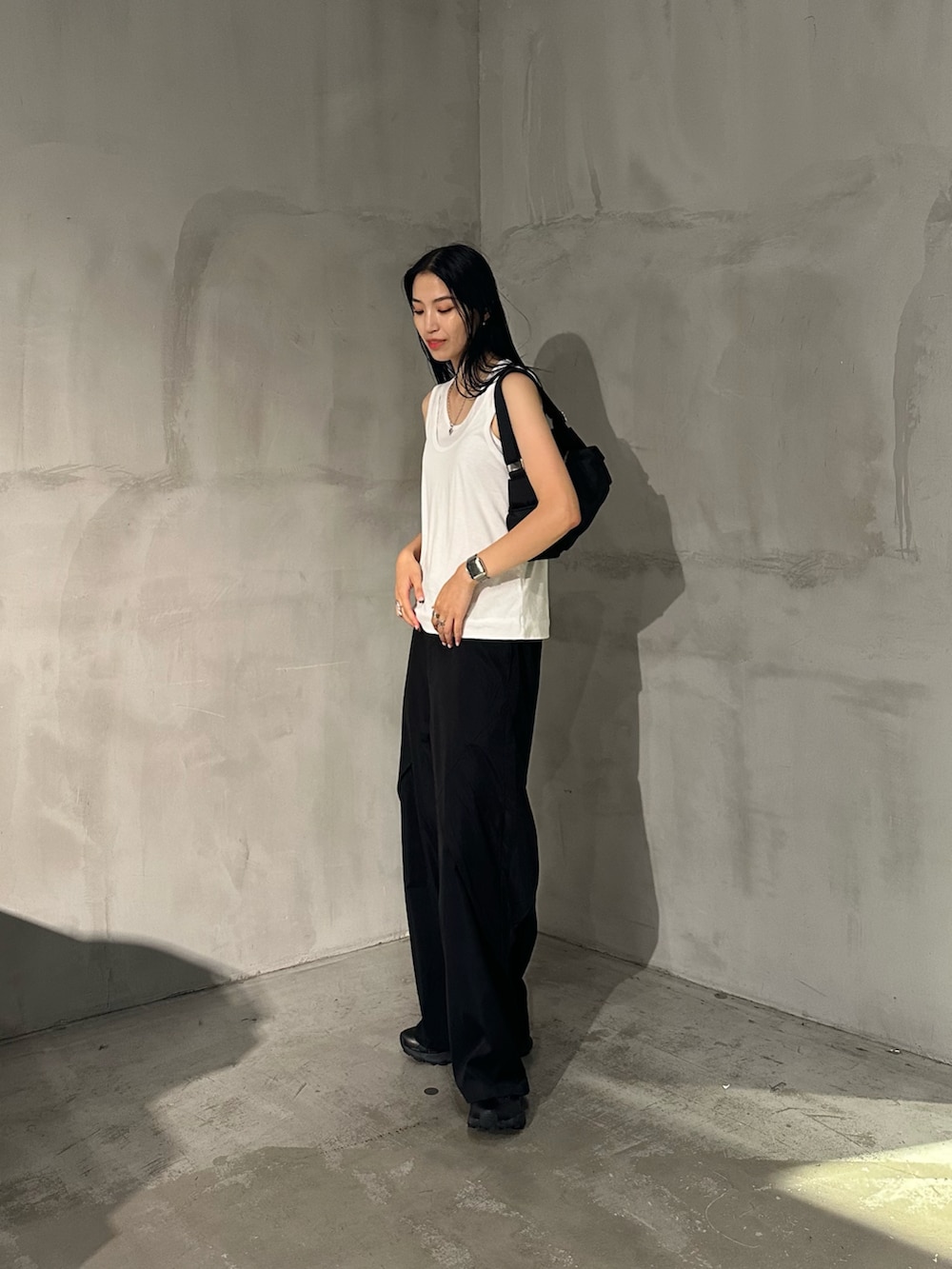 ホワイト系のタンクトップ、ブラック系のその他パンツ、ブラック系のショルダーバッグを着用したレディースの夏コーディネートの4枚目の写真