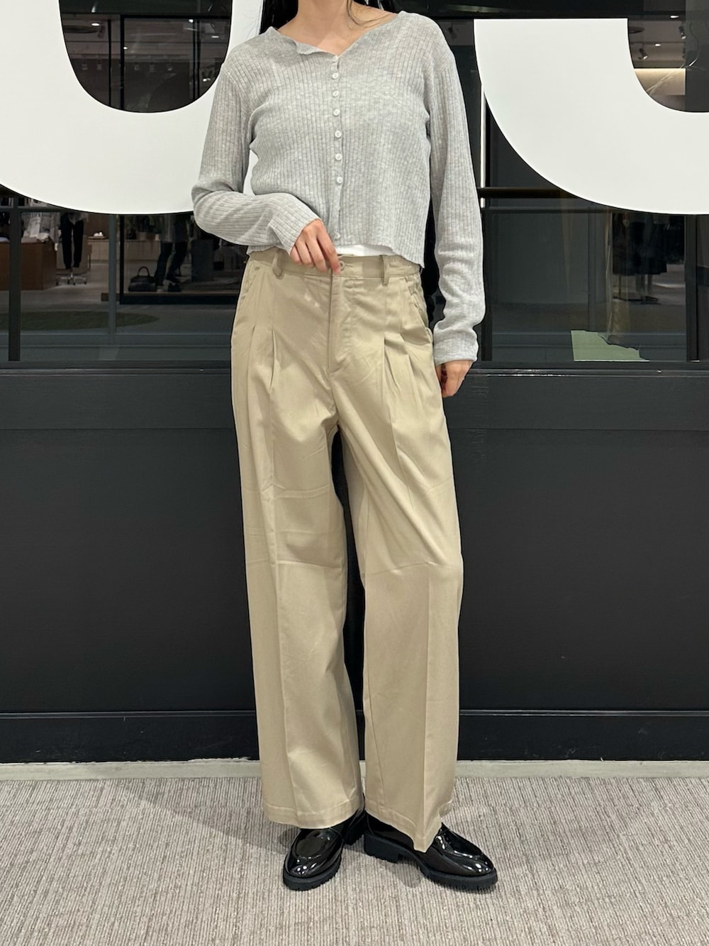 グレー系のカーディガン/ボレロ、ホワイト系のキャミソール、ベージュ系のチノパンツを着用したレディースの春コーディネートの4枚目の写真